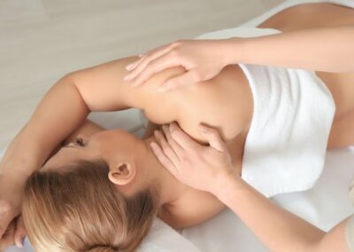 Doula gibt schwangeren Frau eine Schwangerschaftsmassage in Frankfurt. Die Schwangere liegt entspannt in Seitenlage auf einer bequemen Massageliege.