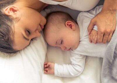 Baby schläft sicher bei Mama im Bett. Die Mutter hat alles zur sicheren Schlafumgebung im Säuglingspflegekurs in Frankfurt bei einer Doula gelernt.